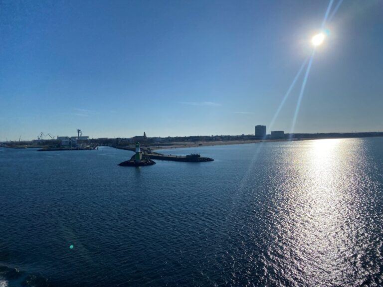 Grünes Leuchtfeuer auf der Westmole von Warnemünde mit Leuchtturm und Strand