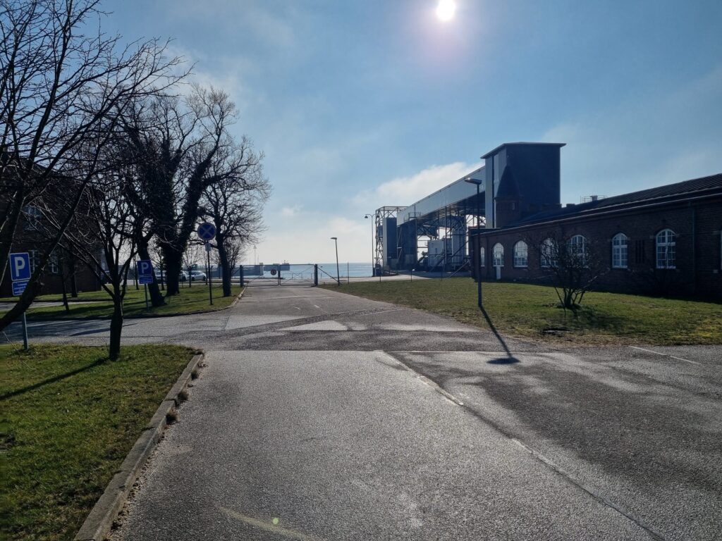 Adgangsvejen til Gedser Færgehavn med landgang, den gamle stationsbygning og havet