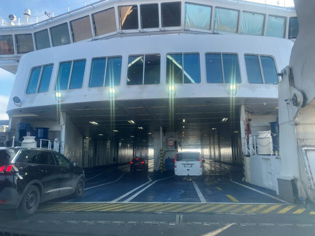 Auto's rijden via de boeg het autodek van de Scandlines-veerboot op