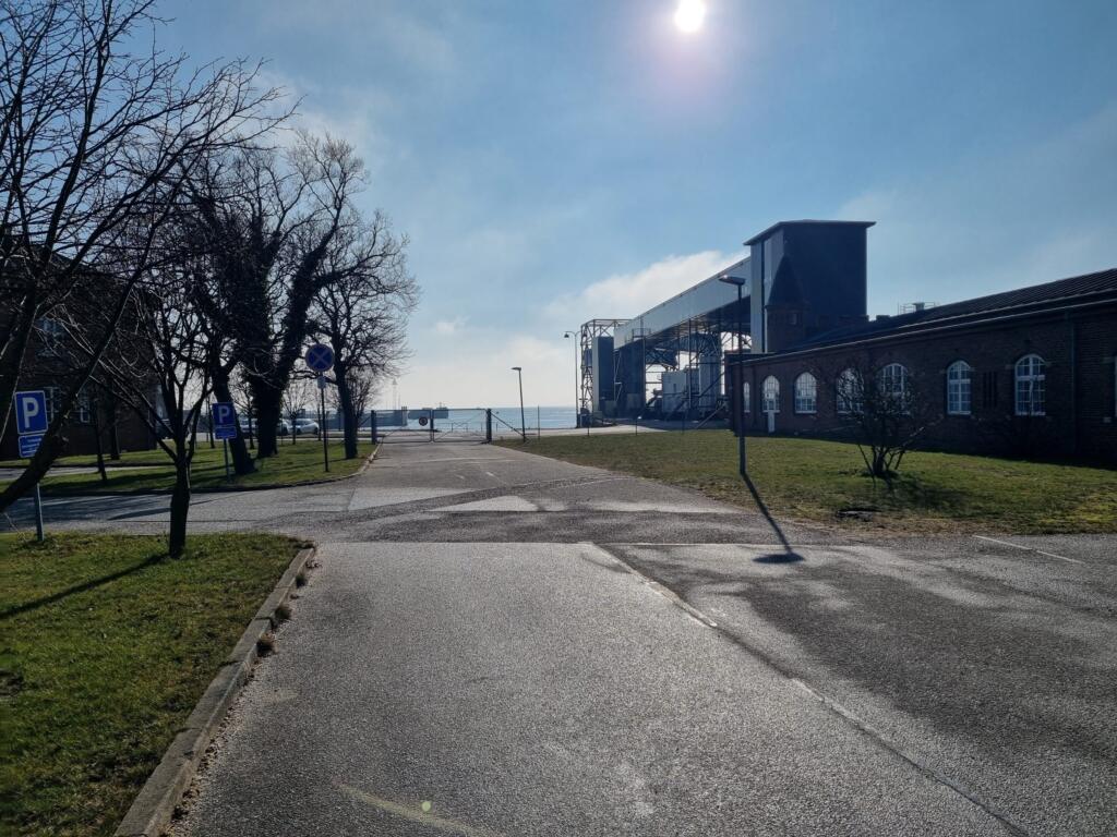 Toegangsweg naar de haven van Gedser met loopbrug, oud stationsgebouw en zee