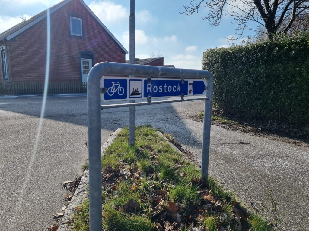 Blå cykelskylt i Gedser som pekar mot färjan till Rostock